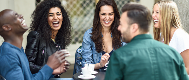 A group of 5 adults drinking coffee and laughing