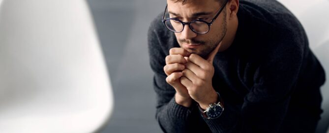 a man looking anxious while sat down